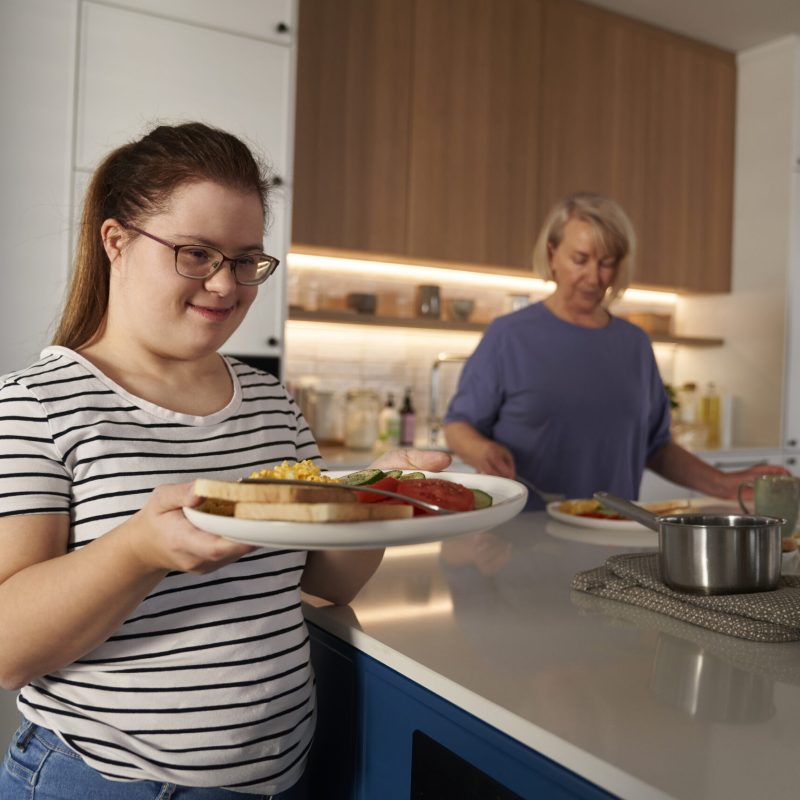 Down syndrome woman serving breakfast